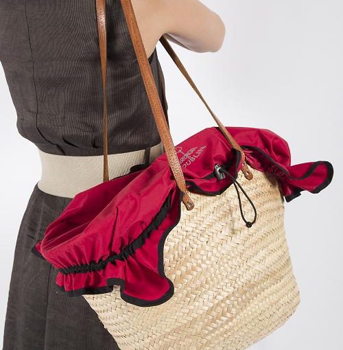 Model wears red Crate Cover over straw handbag
